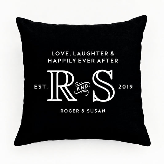 A square black cushion with white printed text and monogram design reading 'LOVE, LAUGHTER & HAPPILY EVER AFTER', large 'R & S' initials, 'EST. 2019', and 'ROGER & SUSAN'.