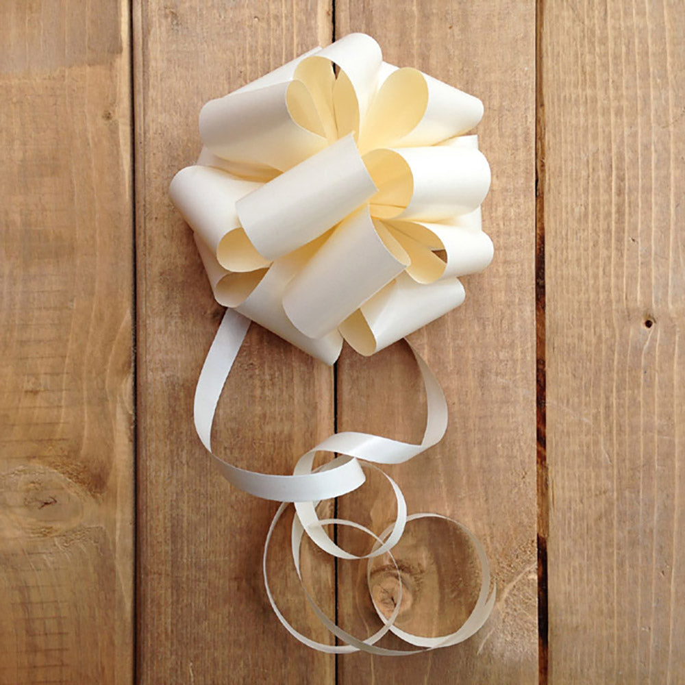 A handmade ivory wedding car door bow on a wooden background.