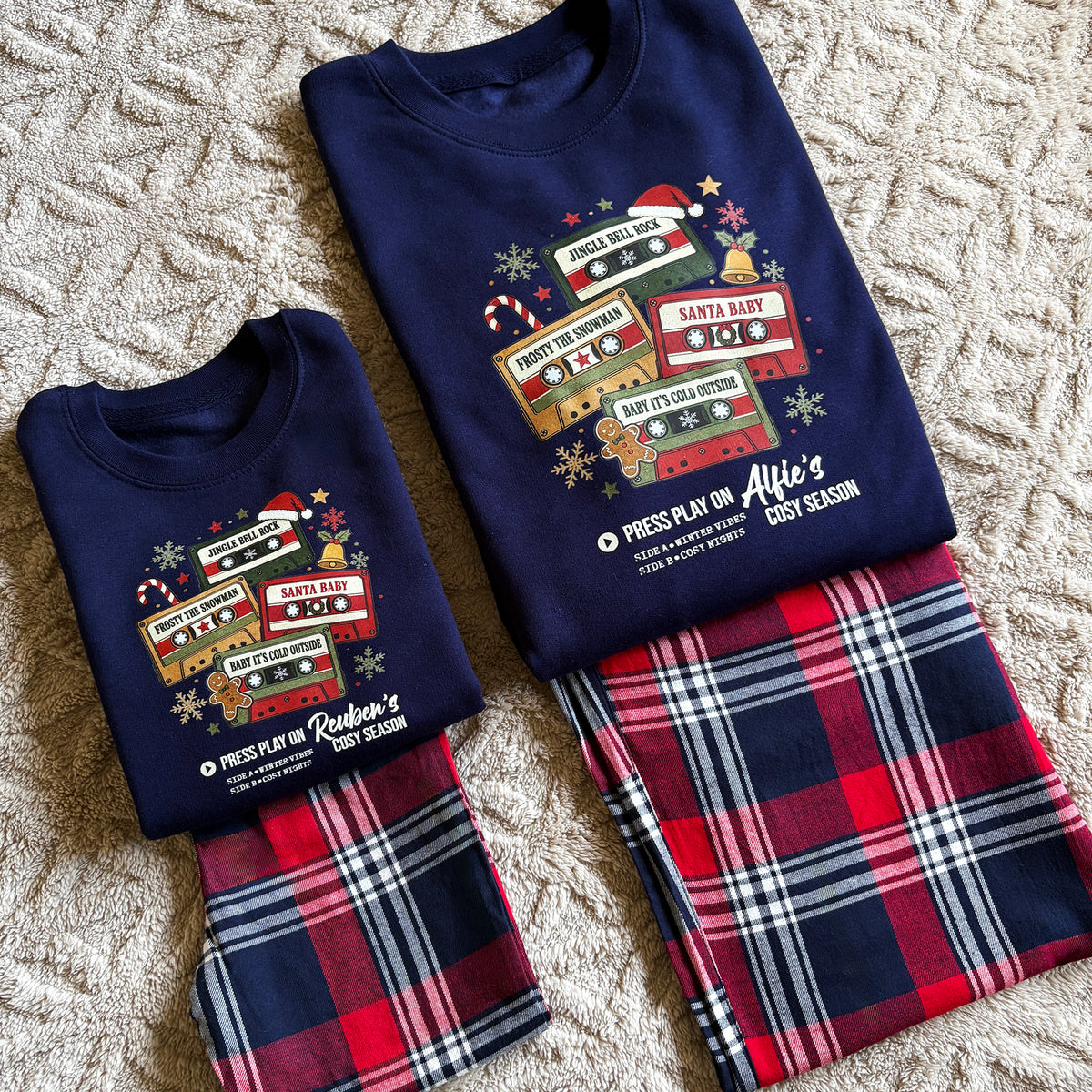 A Navy blue Sweatshirt with Christmas Mix Tape Music Design, Personalised with your name. Paired with Red and Navy Tartan Trousers.