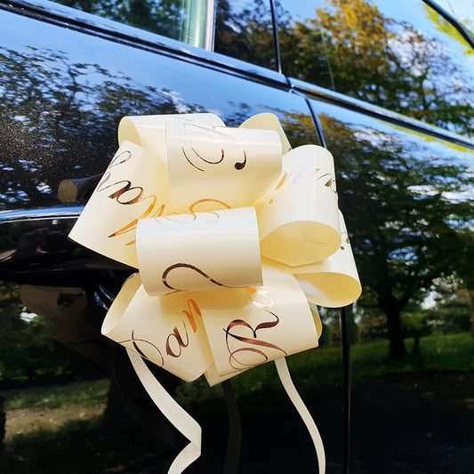 An ivory personalised wedding car door bow, with rose gold print. 