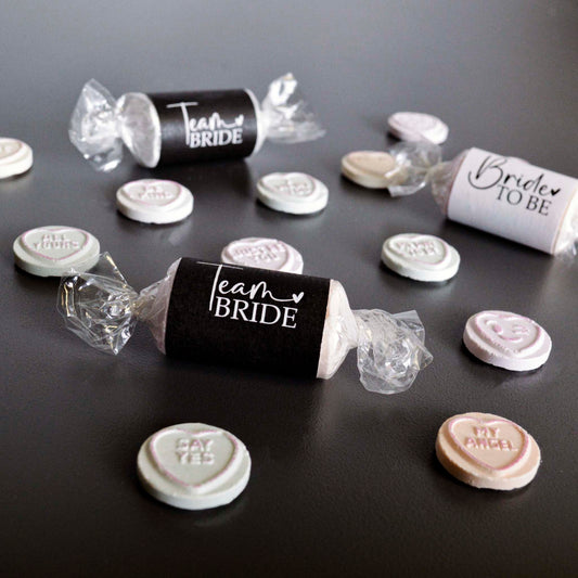 Team Bride Hen Party Sweets in black and white. Love Hearts scattered out of their packets. 